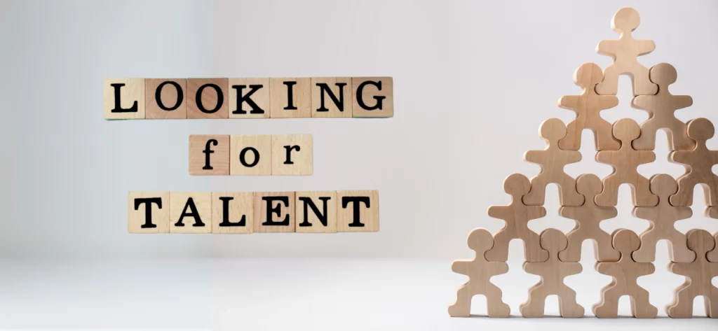 Schrift "Looking for Talent" und Menschenpyramide